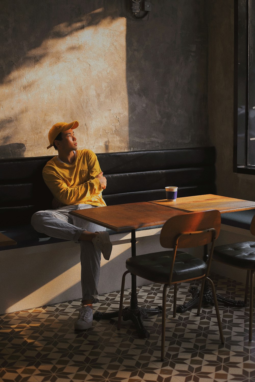 man in yellow dress shirt sitting on black chair