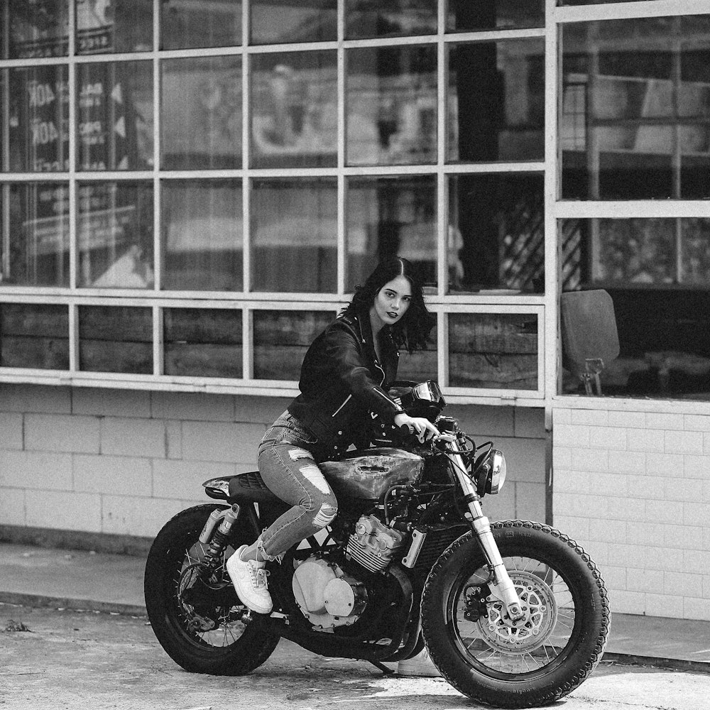 Foto en escala de grises de un hombre montando una motocicleta