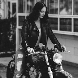 Group of female bikers in dark leather jackets with fiery background