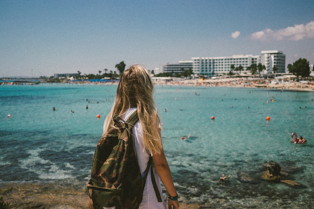 woman in brown jacket standing on beach during daytime