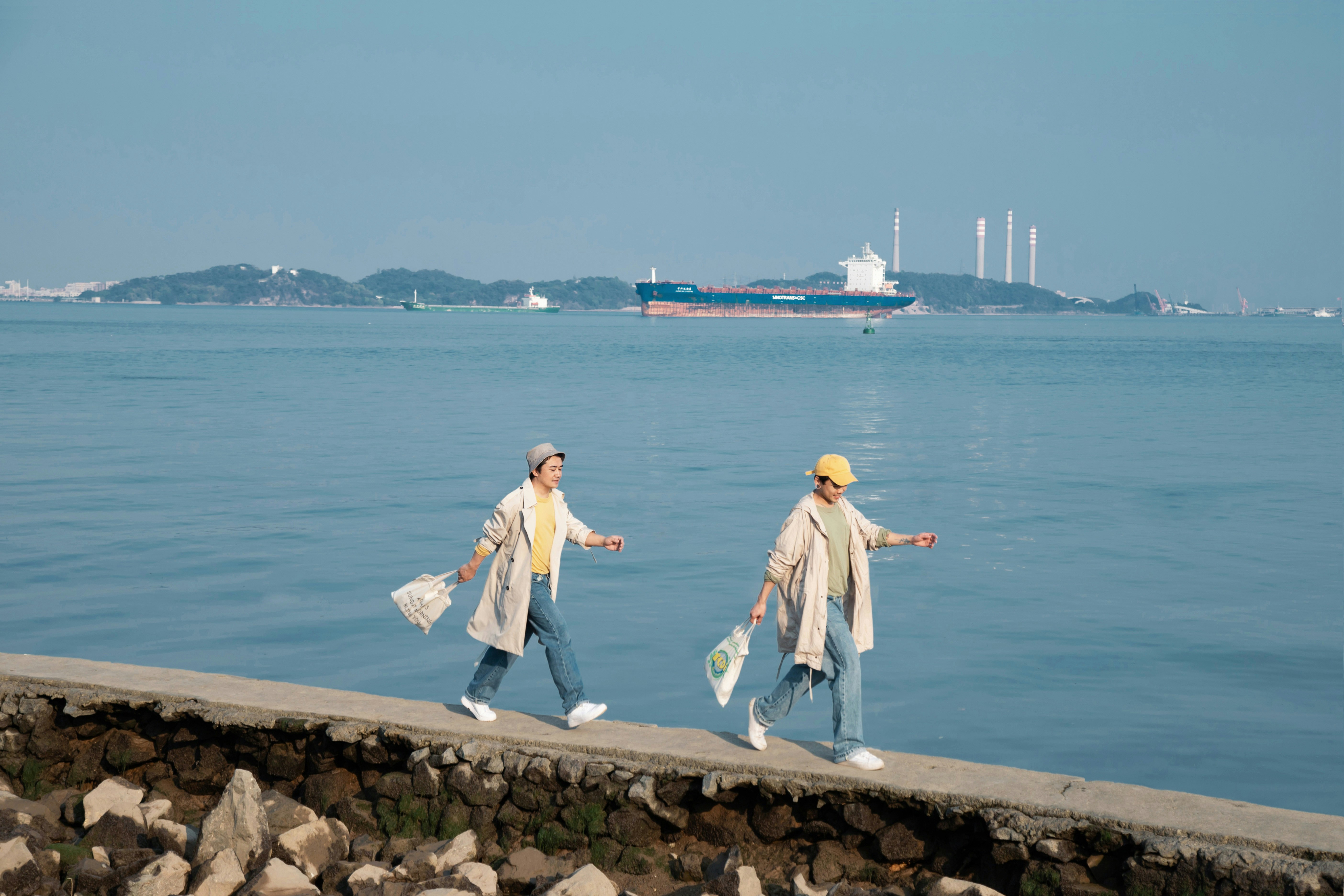 man and woman standing on concrete dock near body of water during daytime
