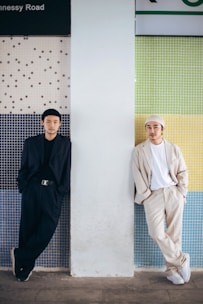 man in black thobe standing beside man in white thobe