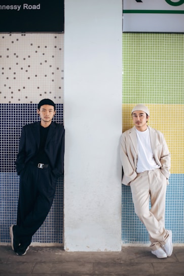 man in black thobe standing beside man in white thobe