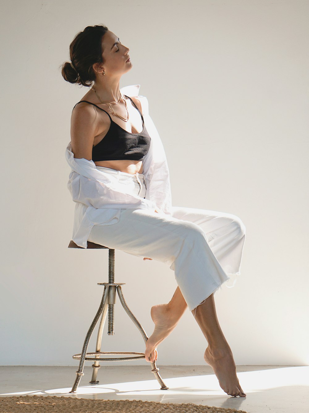 woman in black brassiere and white pants sitting on seat