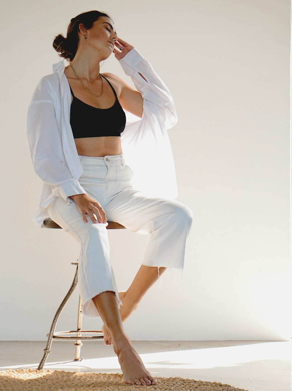 woman in white blazer and white skirt sitting on chair