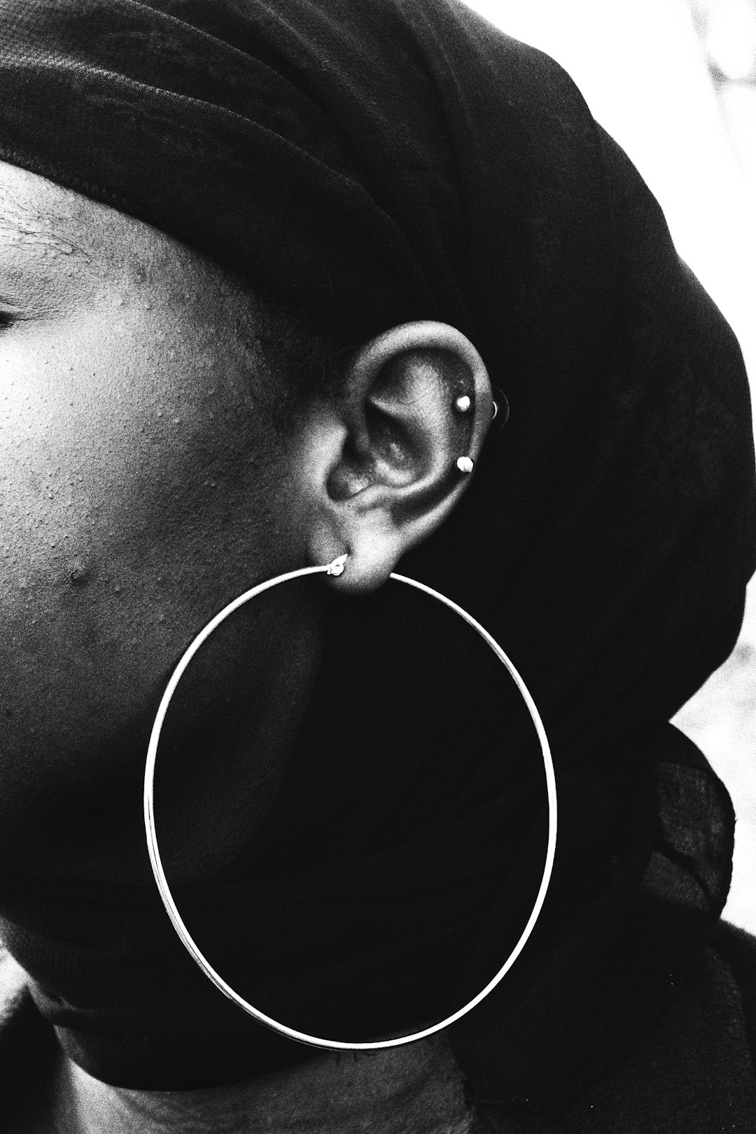 grayscale photo of person with white earbuds