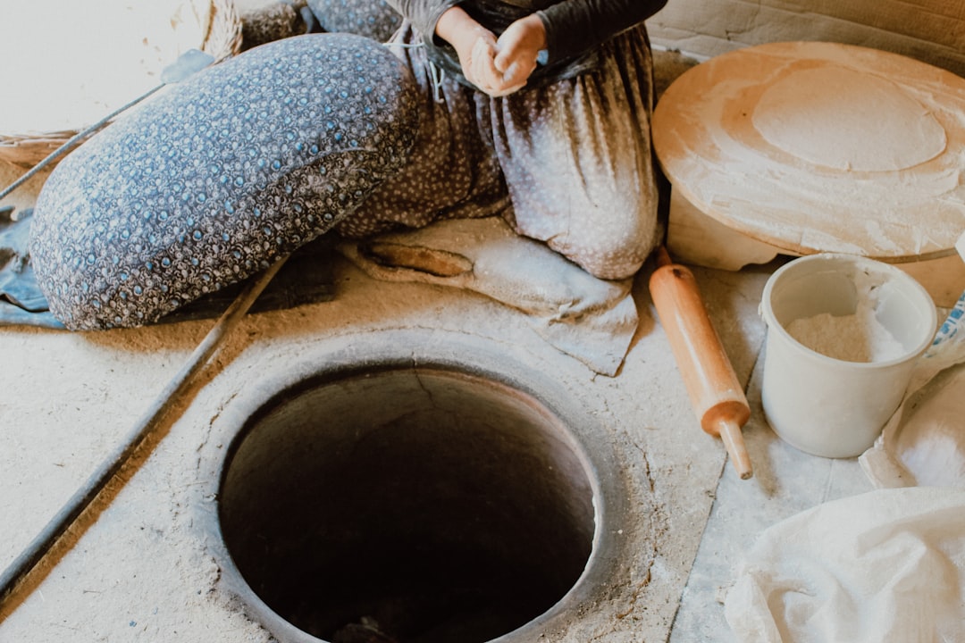 woman in black and white dress sitting on brown clay pot