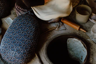 A warm kitchen scene showing hand-preparation of ariselu with turmeric and jaggery.
