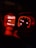 A car dashboard showing illuminated dials and indicators in a dimly lit setting. The left display screen has text in Portuguese, likely indicating a mode or instruction, and shows a digital clock displaying 18:50. The speedometer and RPM gauge are lit up in red hues.