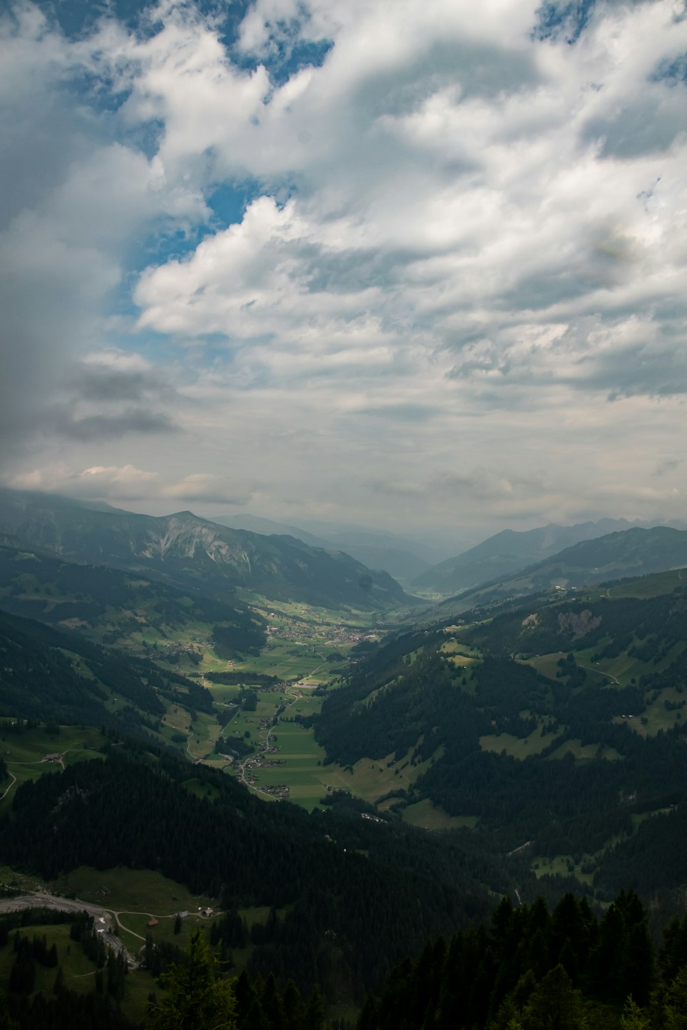 montagnes vertes sous des nuages blancs pendant la journée