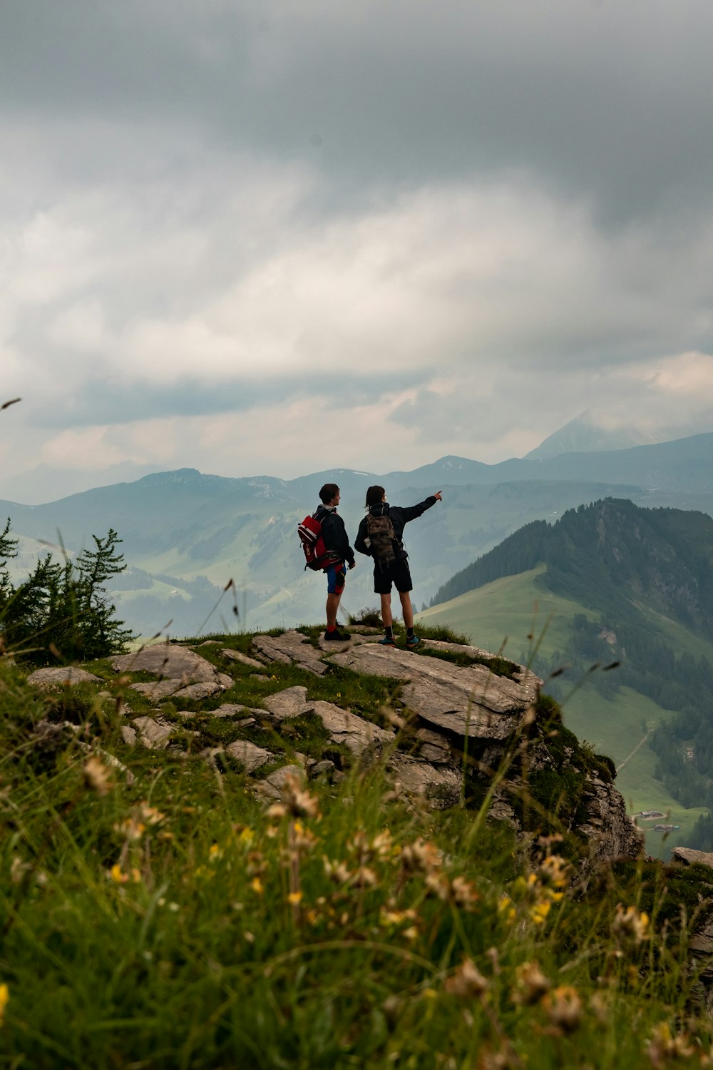 man in black jacket standing on rock mountain during daytime