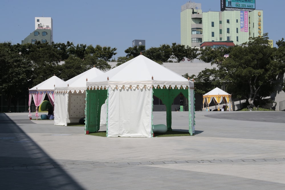 white and green tent near green trees during daytime