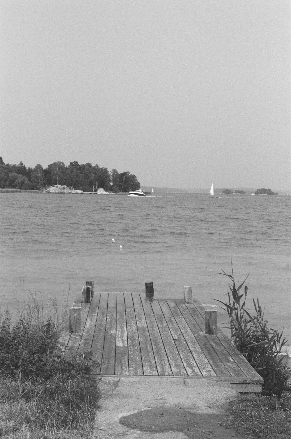 grayscale photo of wooden dock on body of water