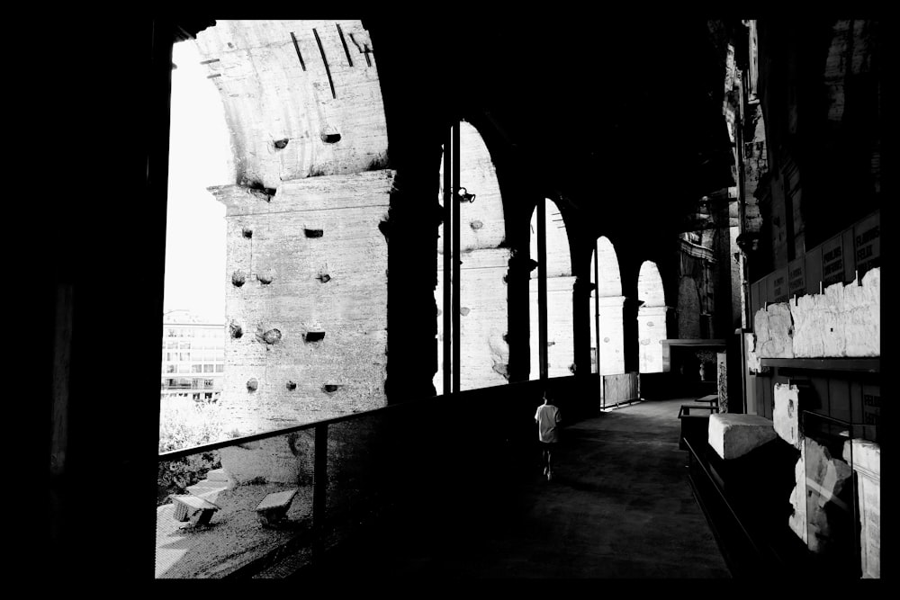 grayscale photo of people walking on hallway