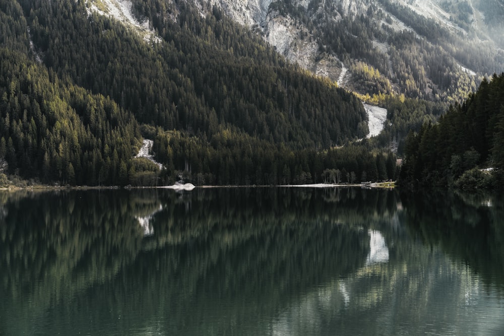 green and white mountains beside lake during daytime