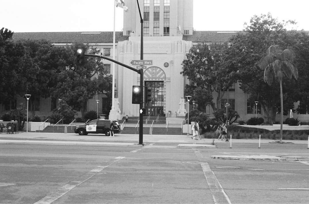 grayscale photo of cars on road near buildings