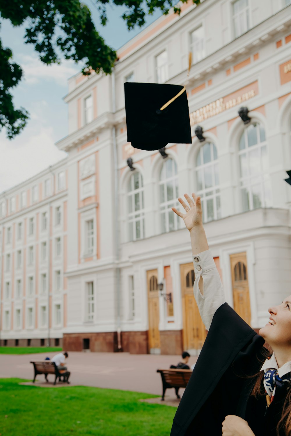 man in black academic dress holding black academic hat