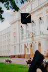 man in black academic dress holding black academic hat
