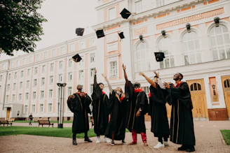 people in black academic dress standing on green grass field during daytime