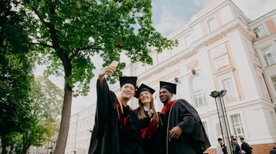 3 women in black academic dress standing near green tree during daytime