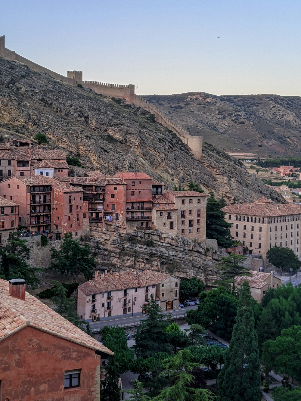 brown and white concrete buildings on mountain