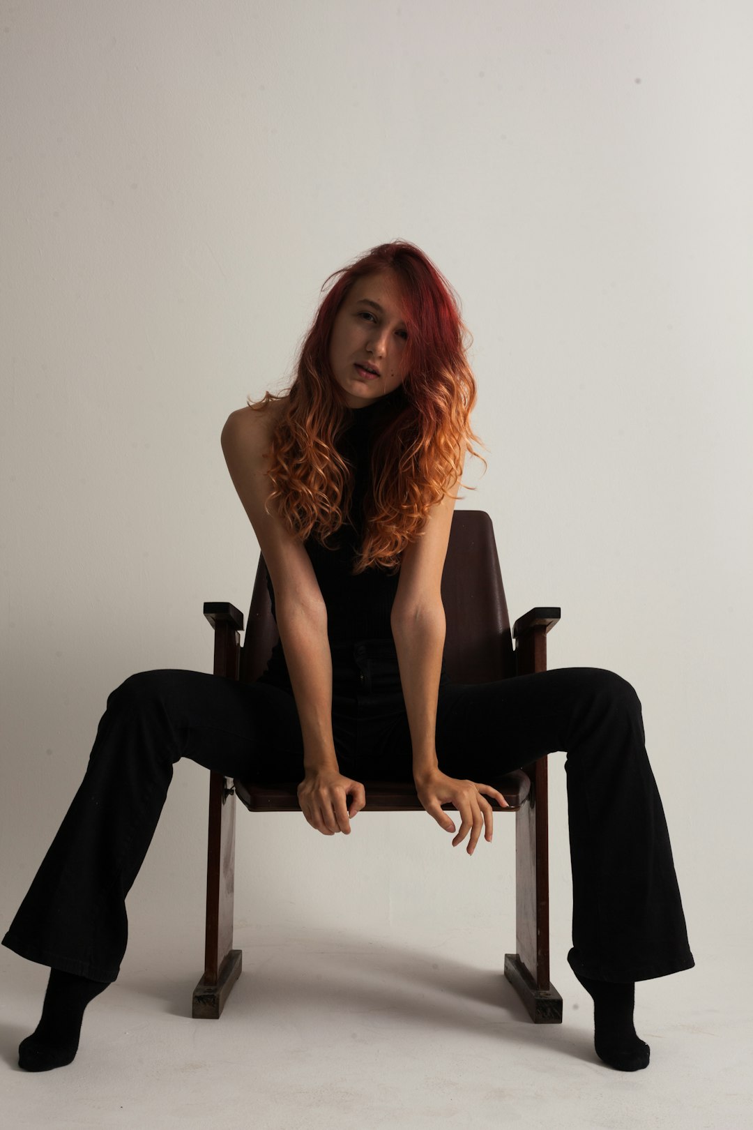 woman in black sleeveless dress sitting on chair