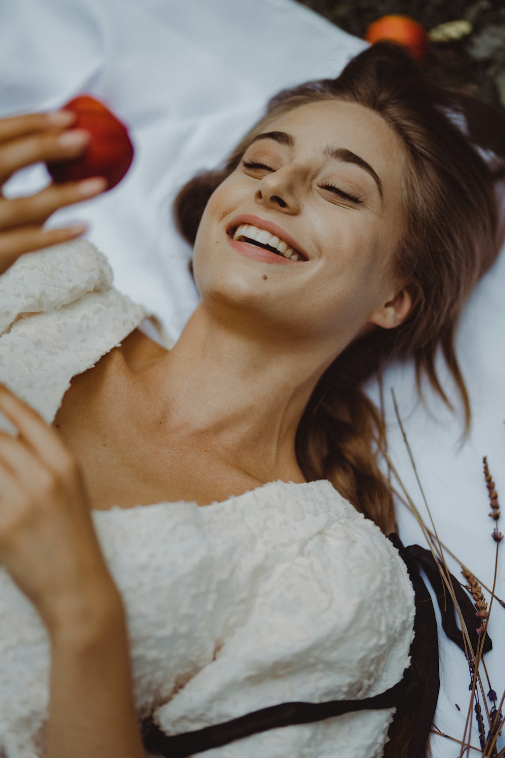 a woman laying down with an apple in her hand