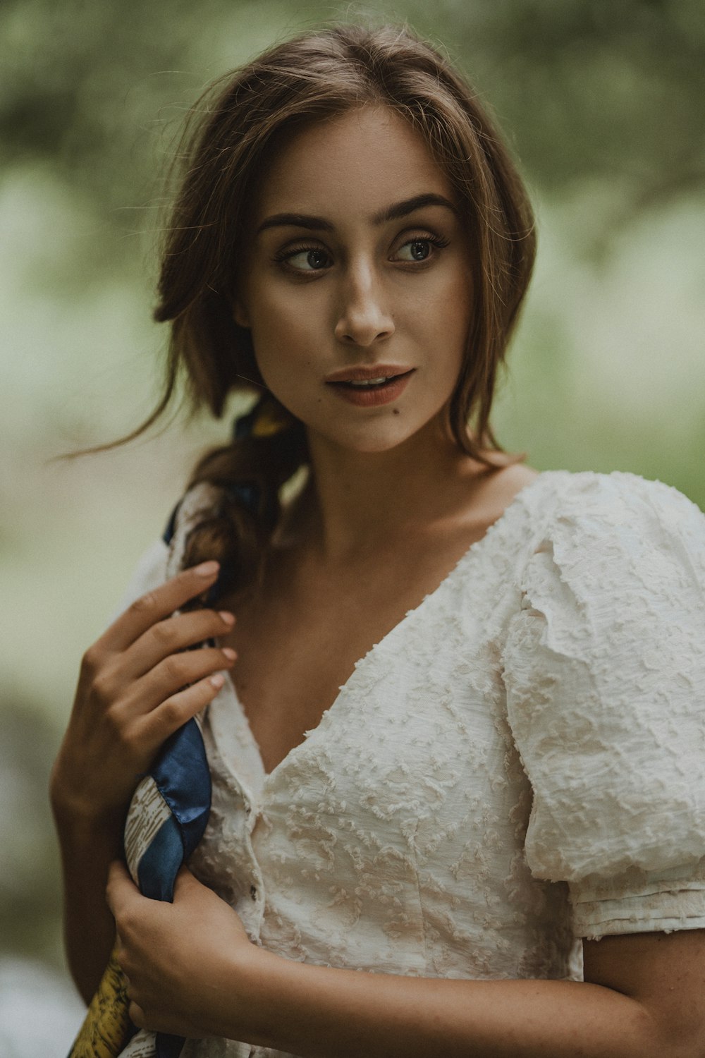 a woman in a white dress holding a blue umbrella