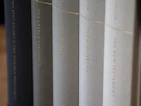 A simple black and white package of books with one book highlighted in soft color grading.