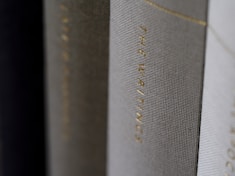 A close-up view of the spines of several hardcover books, with one prominently displaying the title 'THE WRITINGS' in gold lettering.