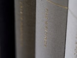 A close-up view of the spines of several hardcover books, with one prominently displaying the title 'THE WRITINGS' in gold lettering.