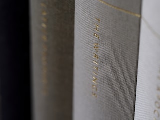 A close-up view of the spines of several hardcover books, with one prominently displaying the title 'THE WRITINGS' in gold lettering.