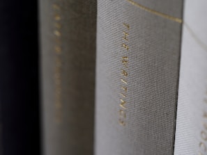 A close-up view of the spines of several hardcover books, with one prominently displaying the title 'THE WRITINGS' in gold lettering.