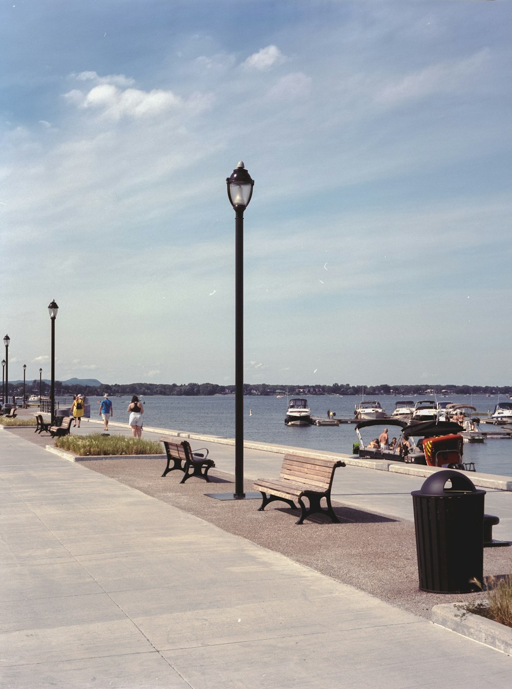 people sitting on bench near body of water during daytime