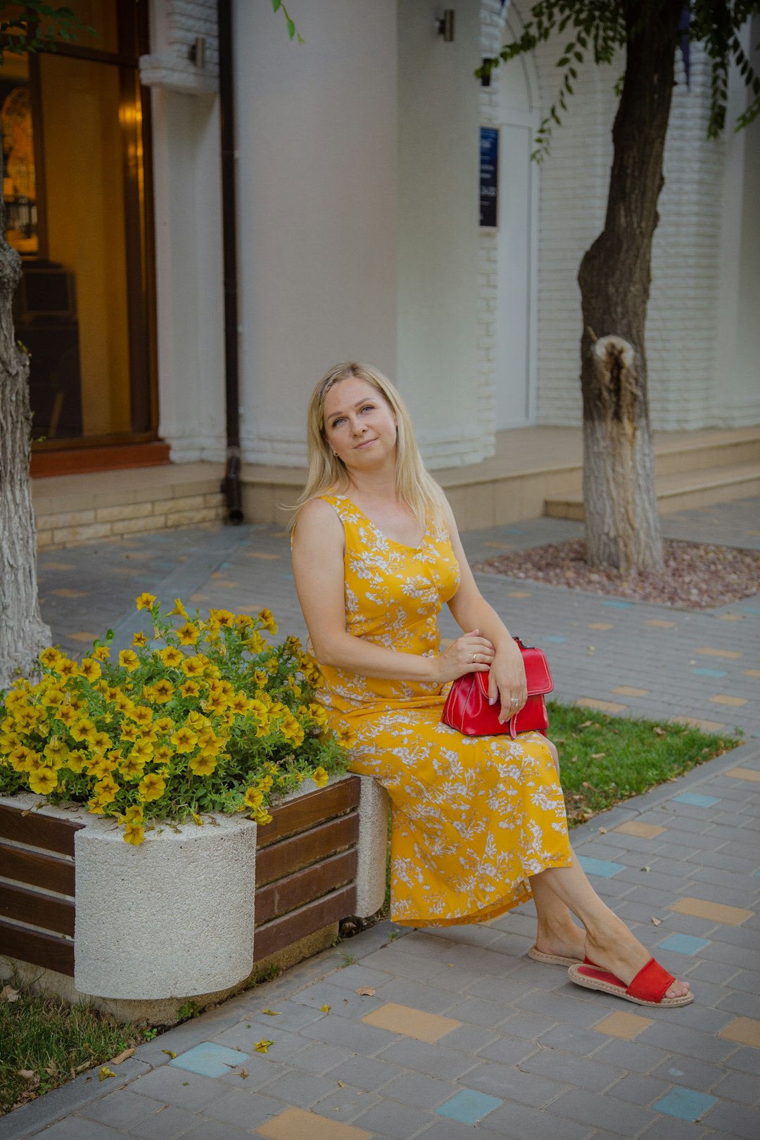 woman in yellow sleeveless dress holding bouquet of flowers