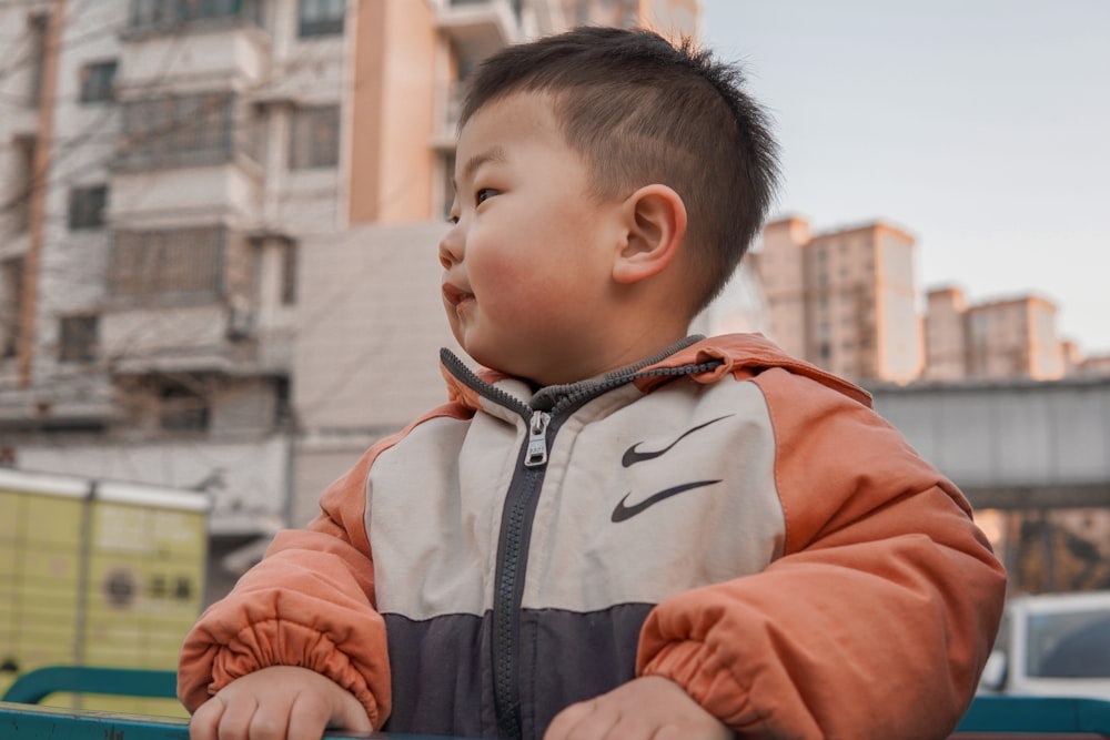 boy in orange and gray zip up jacket