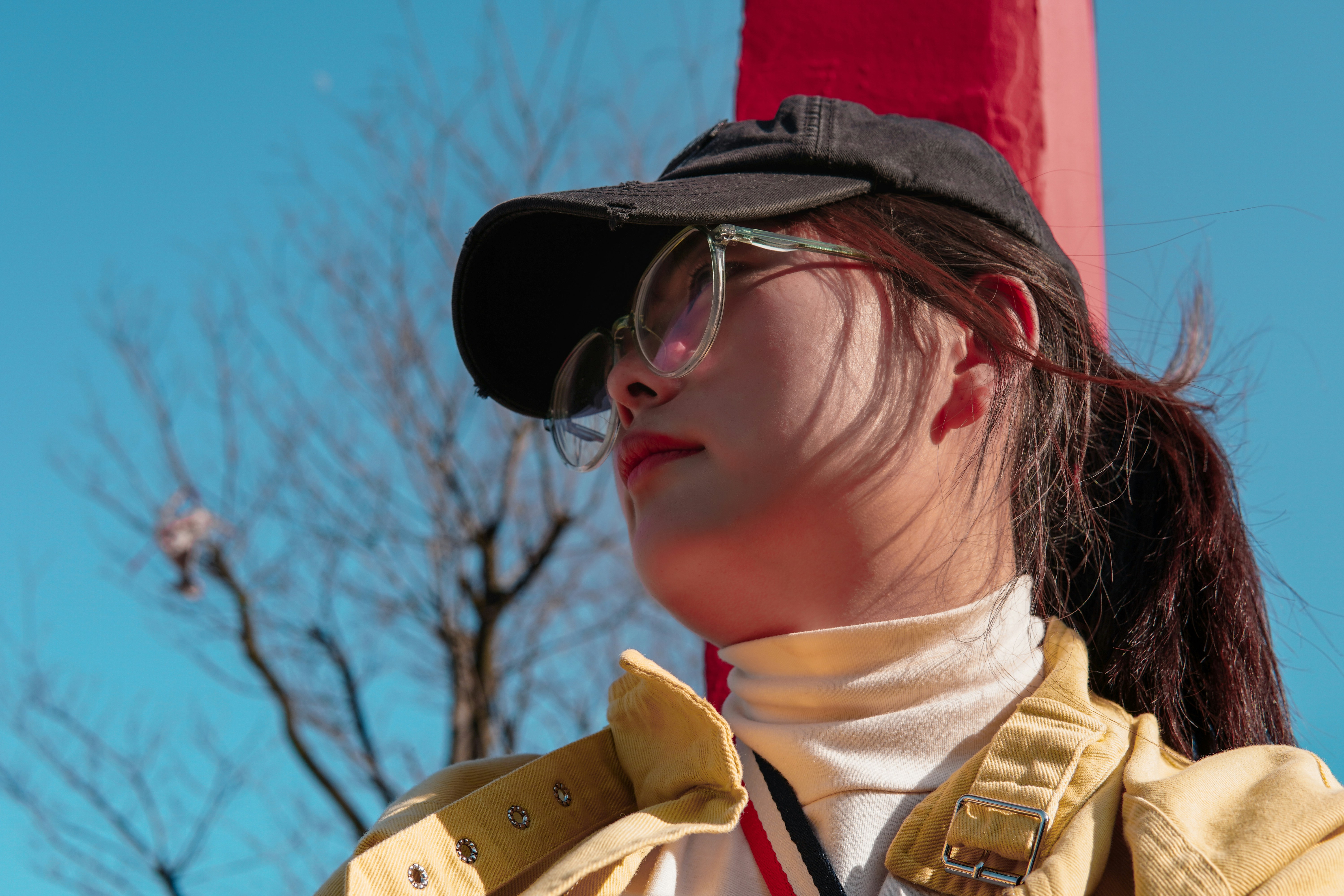 wanita dengan topi hitam dan merah dan jaket coklat