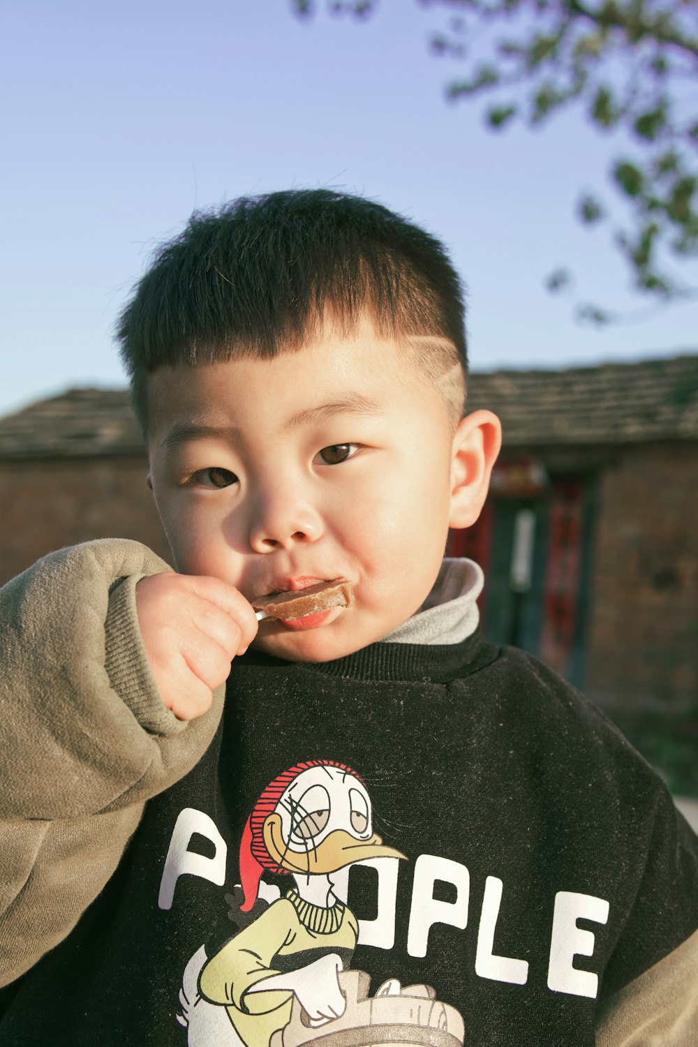 boy in black and white sweater eating food