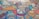 A vibrant and colorful mosaic composed of various geometric shapes and intricate patterns. Each piece features unique designs, including floral, mandala, and paisley motifs, creating a rich tapestry of artistic elements. The image is filled with both cool and warm tones, resulting in a visually engaging and dynamic composition.