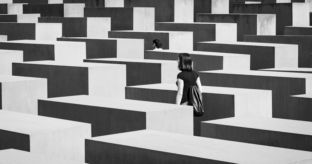 woman in black and white stripe dress standing on white concrete stairs