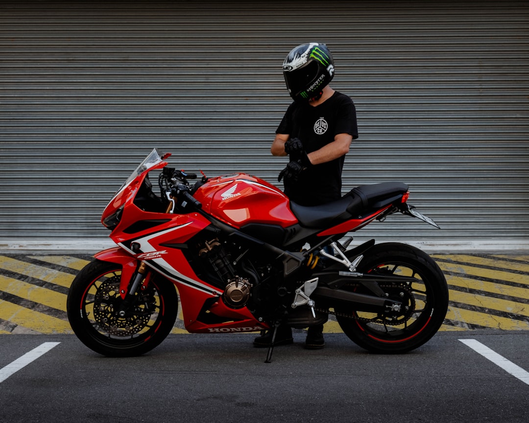 man in black and red motorcycle helmet riding red and black sports bike