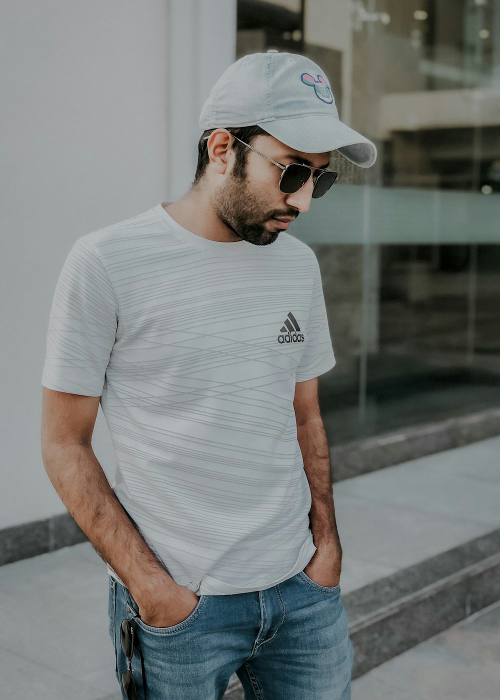 man in white crew neck t-shirt and blue denim jeans wearing white sunglasses