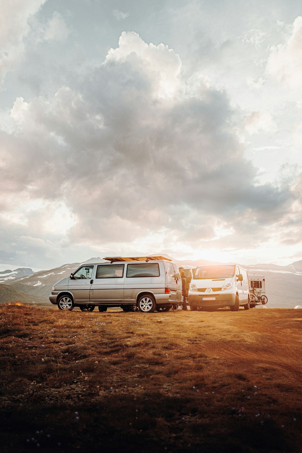 silver suv on brown field under white cloudy sky during daytime