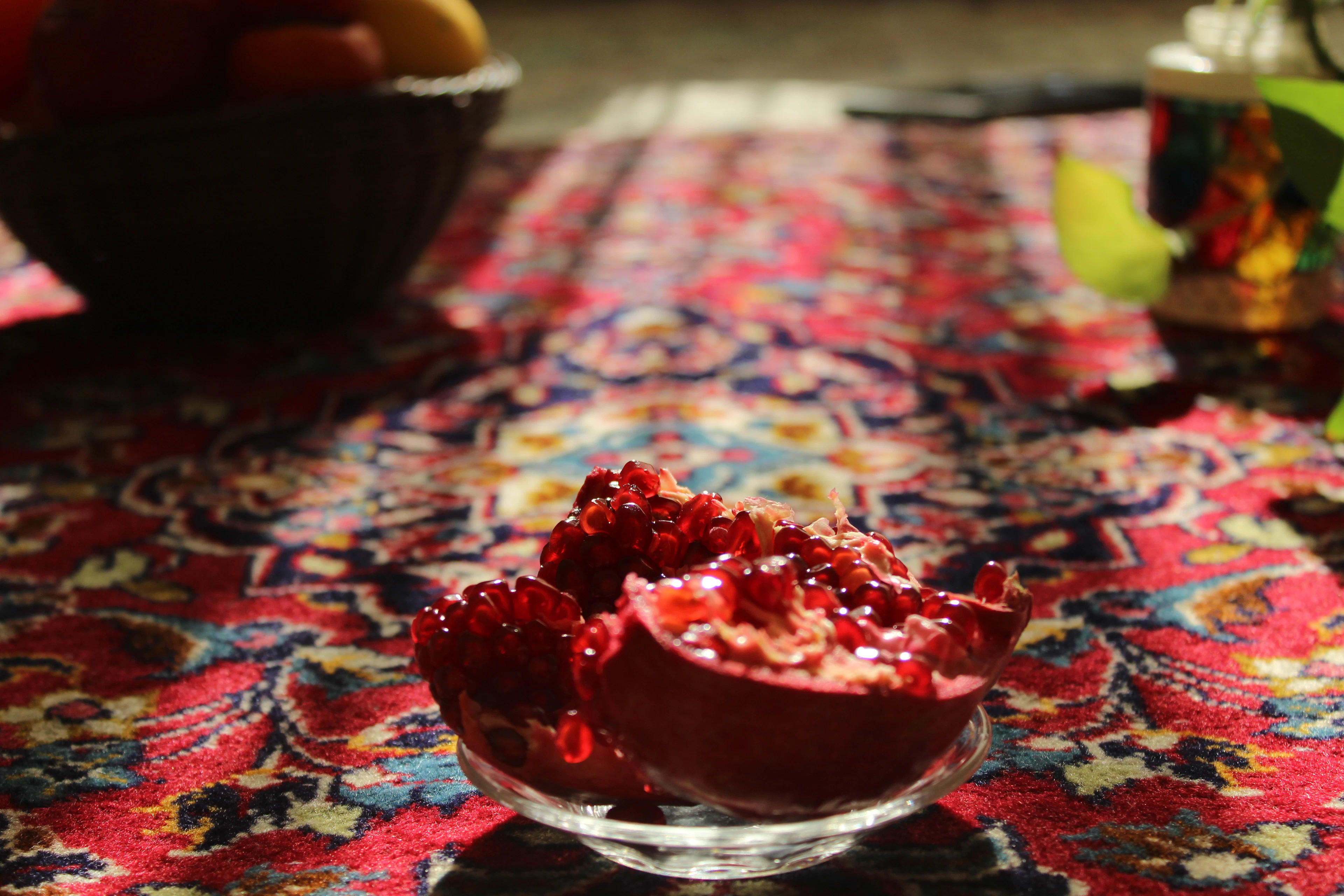 A bowl of pomegranate seeds on a patterned carpet, Azerbaijan
