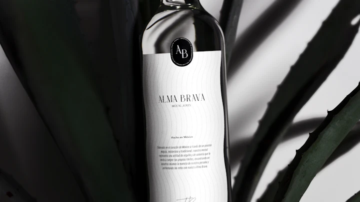 Mezcal bottle with a graphic paper label, photographed against a dark studio backdrop