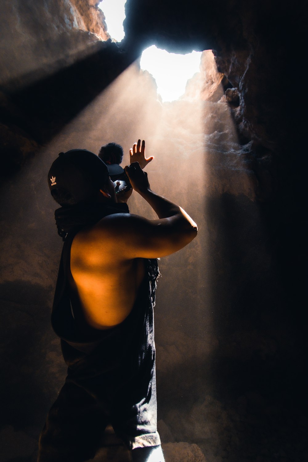 man in black tank top holding camera