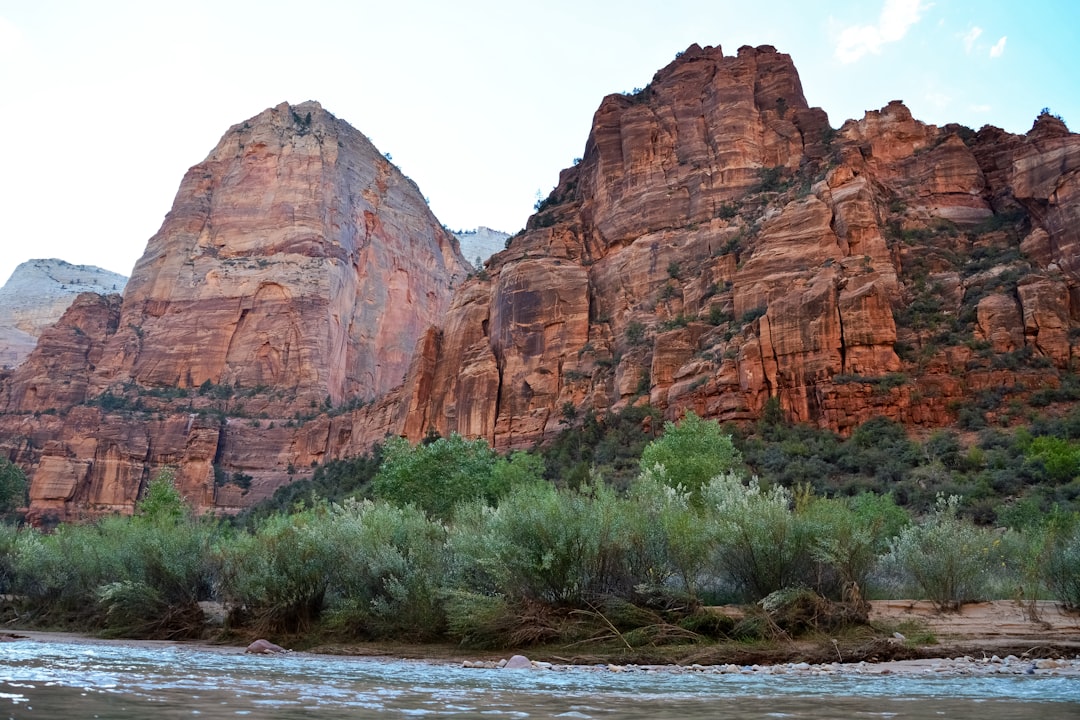 brown rocky mountain near green grass field during daytime