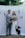 man in gray suit jacket holding woman in white wedding dress