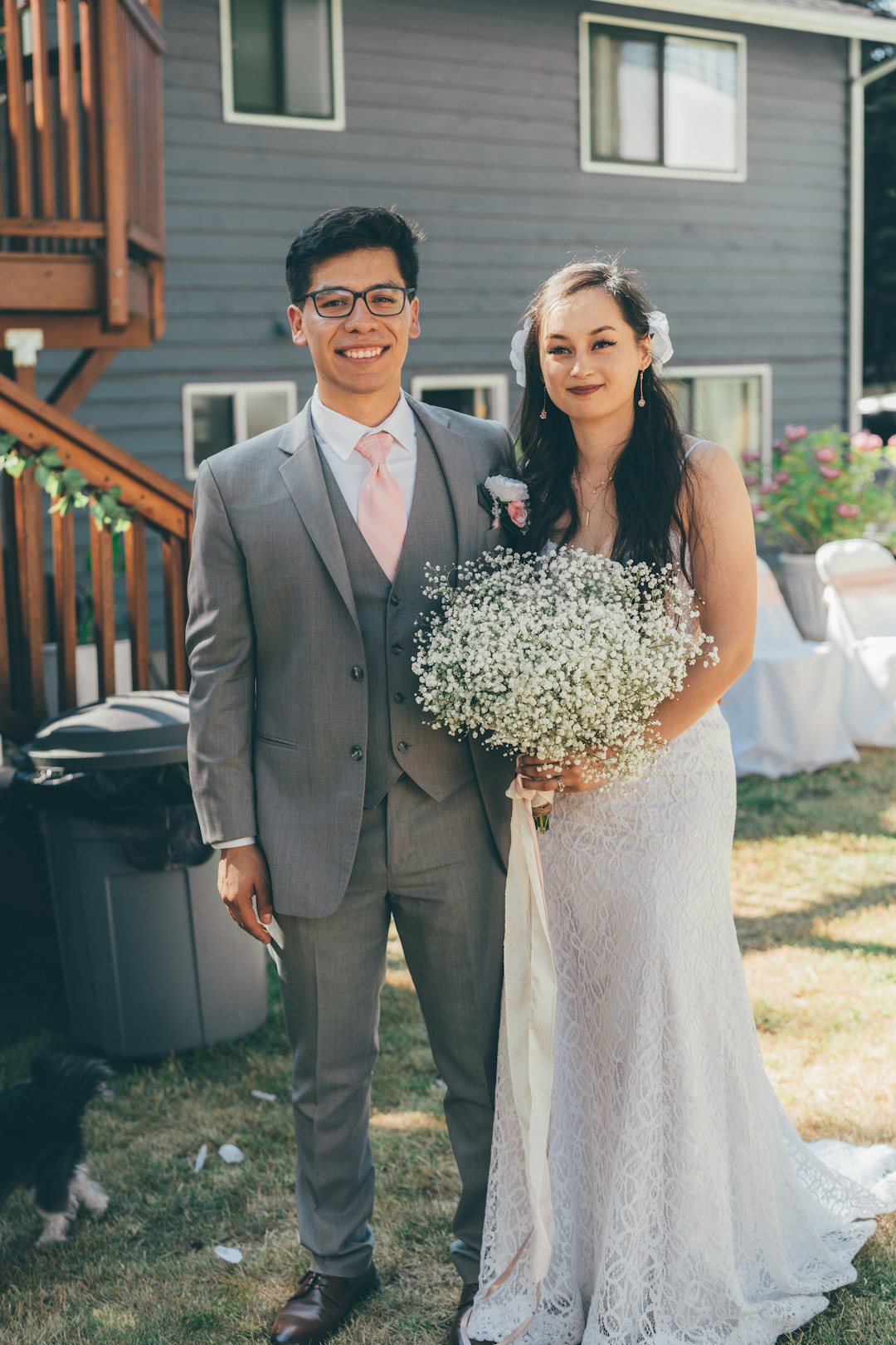 man in black suit jacket holding woman in white wedding dress