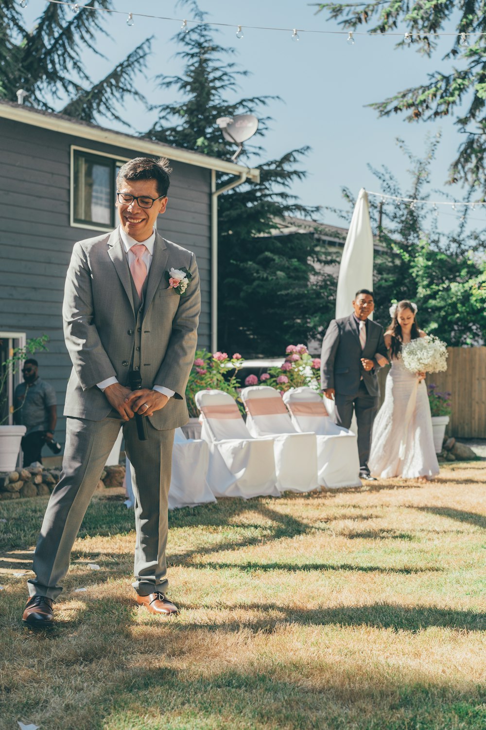 man in gray suit standing on green grass field